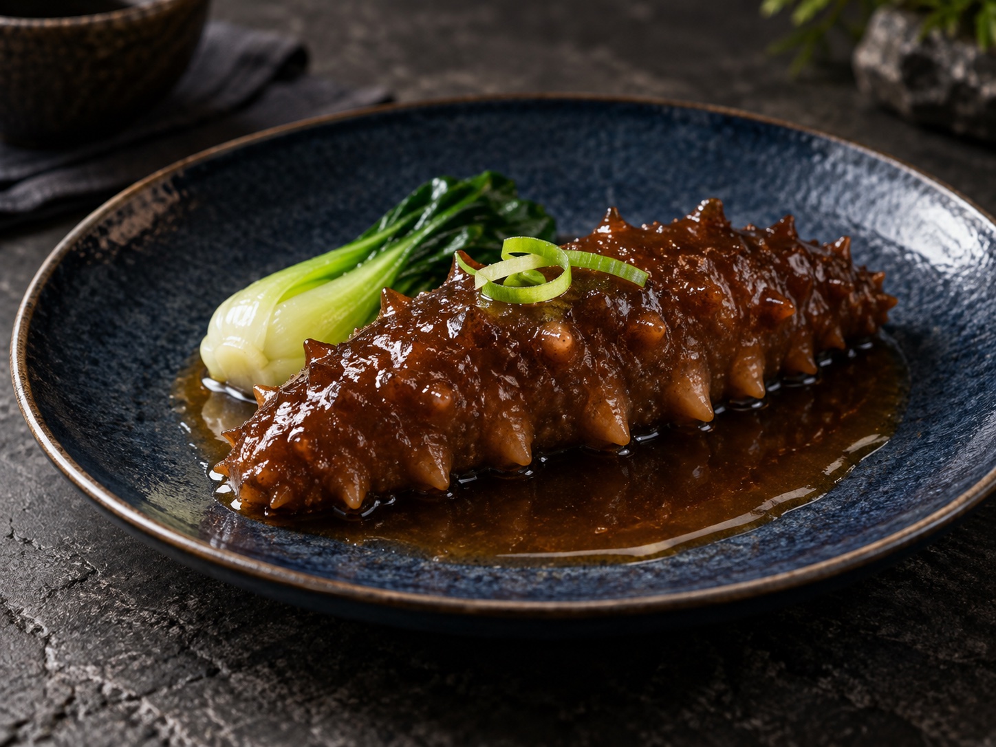 深蓝陶盘上的葱烧海参料理创意图